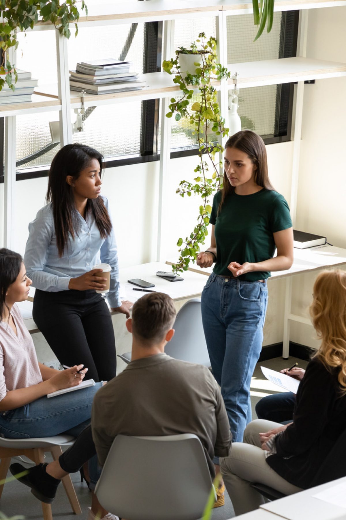 Concerned diverse office employees gather together solve business problems Executive Coach Manchester